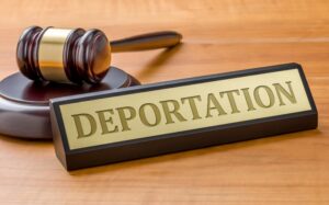 A gavel and a name plate with the engraving Deportation