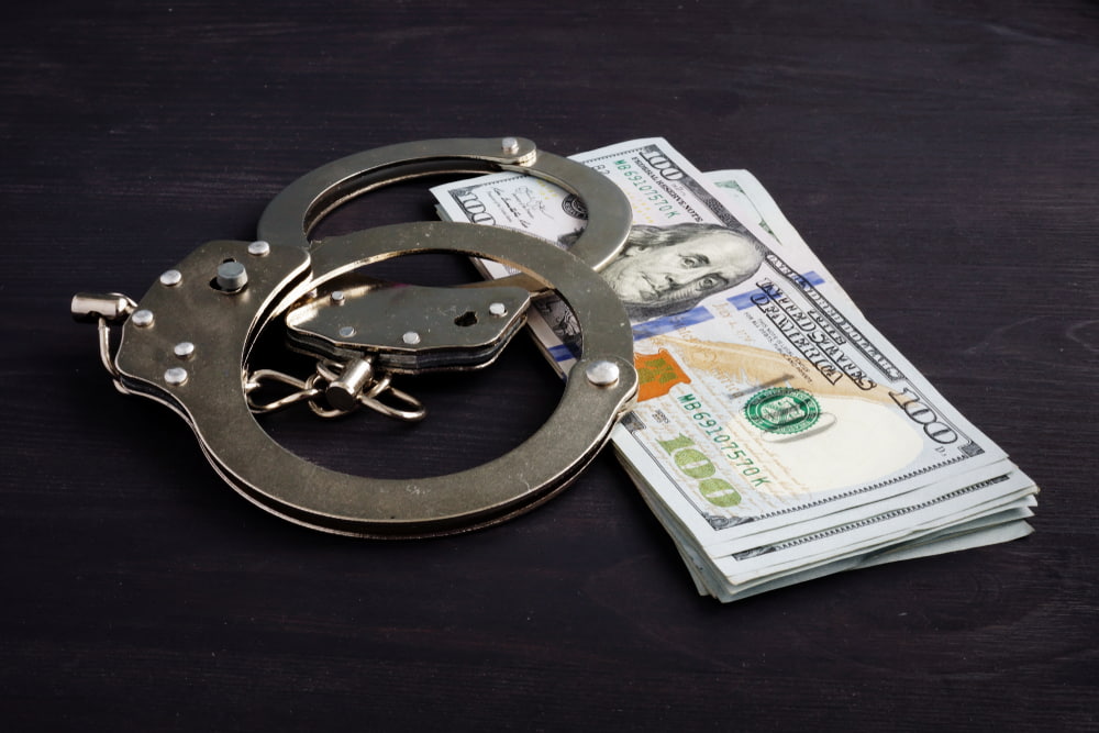 Handcuffs and money representing the article's topic about Bail and Own Recognizance Release