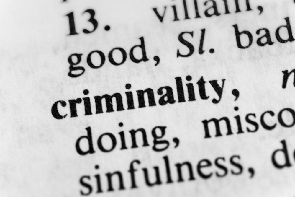 A close-up of a dictionary with the word ‘criminality’ written down, representing the article’s topic about crimes involving moral turpitude.