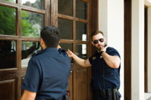 two police men knocking on the door with a search warrant representing the article's topic about Understanding the Basics of Arrest Warrants and Search Warrants in Los Angeles