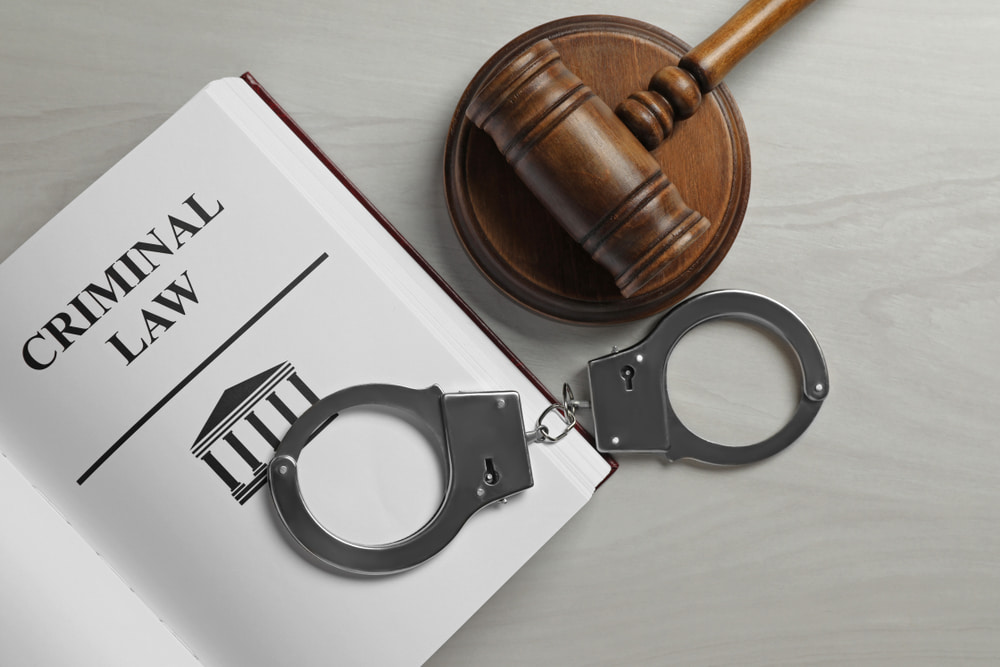 gavel, handcuffs and Criminal law book illustrating article about What is a Criminal Defense Attorney and When Do You Need One?