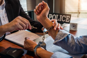 police opening handcuffs from men's hands representing the article about What is Early Termination of Probation