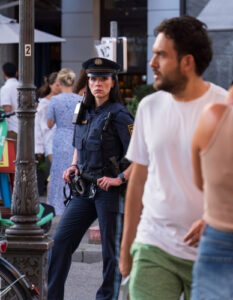 police officer stands alert watching crowd representing the article What is Probable Cause?