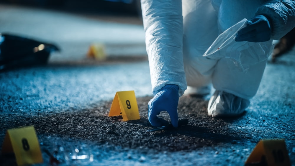 Forensics Specialist Picking a Bloody Knife From Crime Scene illustrating the article about What’s the Burden of Proof in Criminal Cases?