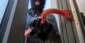 Masked housebreaker entering a house representing the article What Is the Castle Doctrine?