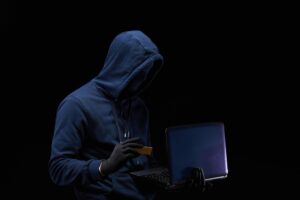 A hacker uses a stolen credit card and laptop to breach secure bank data and commit online theft.