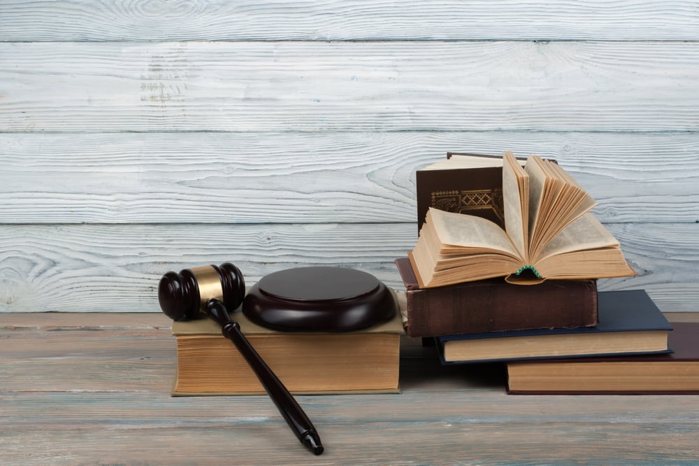 law book with a wooden judges gavel on table illustrating the article Section 1983 Lawsuits in California