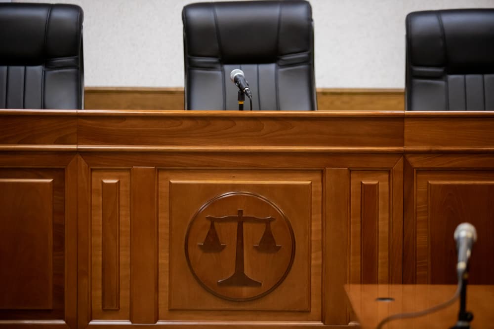 A courtroom and empty judge's chairs