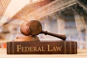 gavel judge with Federal law books on desk of lawyer with court background.